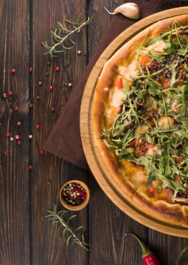 Tahta zemin üzerinde roka olan pizza.