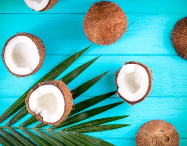 Ahşap masa üzerinde palmiye yaprakları olan hindistan cevizleri