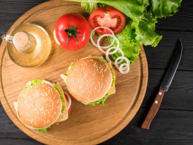 Burgerler ve sarı panodaki taze malzemeler..