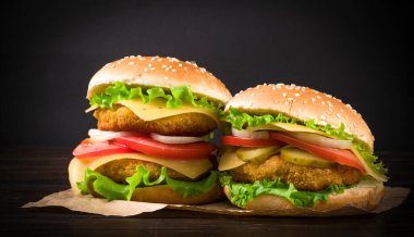Ahşap arka planda iki hamburger.