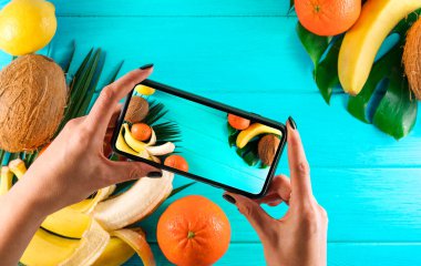  Farklı tropik olgun meyveler ve mavi bir arka planda yer alan palmiye yaprağı çerçevesi.