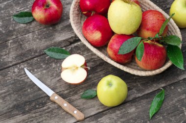 Tahta bir arka planda sepetteki olgun kırmızı elmalar.