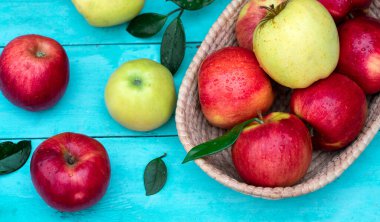 Tahta bir arka planda sepetteki olgun kırmızı elmalar.