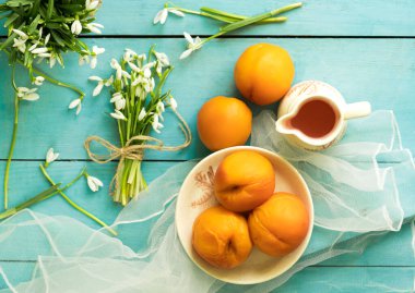 Mavi ahşap arka planda konserve şeftali ve şeftali suyu