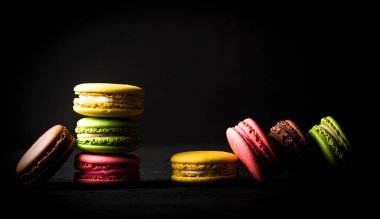 Siyah arka planda renkli badem kurabiyesi.