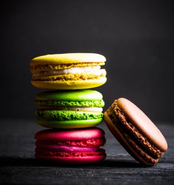 Siyah arka planda renkli badem kurabiyesi.