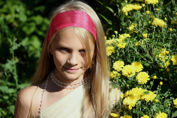 Beauté jeune fille avec des fleurs jaunes dans le jardin — Photo