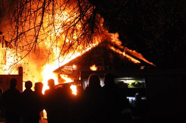 İnsanlar eski bir Ahşap ev yanan bakıyor