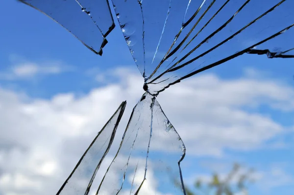 Разбитое стекло, фон разбитого окна на фоне голубого неба — стоковое фото