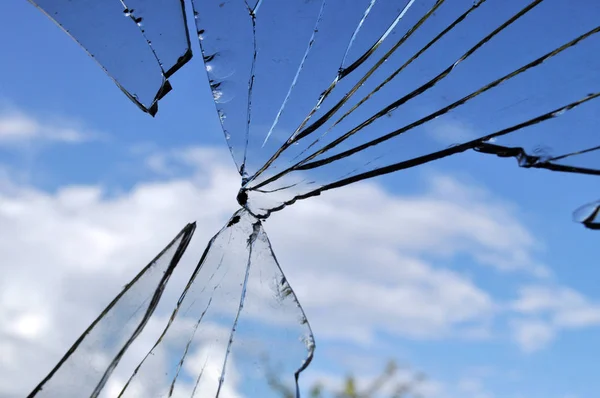 Złamane szkło, tło pękniętego okna przed błękitnym niebem — Zdjęcie stockowe
