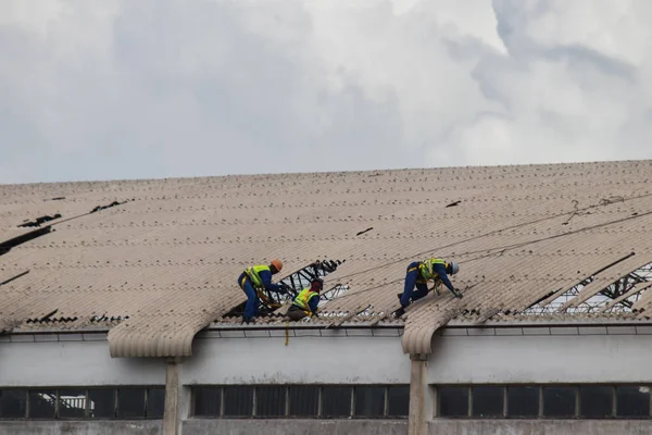 Mozambik ve Zimbabve'de Aftermath Cyclone Idai ve Cyclone Kenneth, hasarlı çatı tamir işçiler 