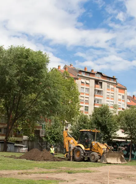 Excavator Digging Ground Man Work Park Buildings — Stock Photo, Image