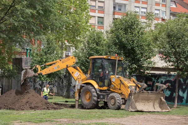 Excavator Digging Ground Man Work Park Buildings — Stock Photo, Image