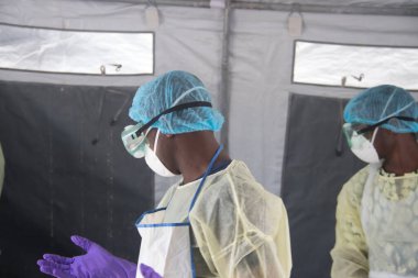 Koruyucu ekipman, önlük, eldiven, google ve maske takan bir doktor. Hem onu hem de seni koruyordu.