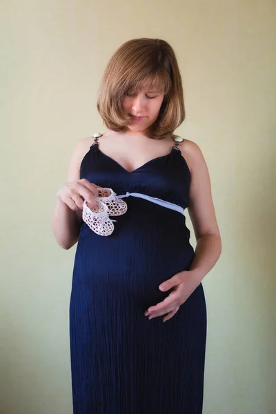 Gravid kvinna smeka hennes mage över gröna mur — Stockfoto