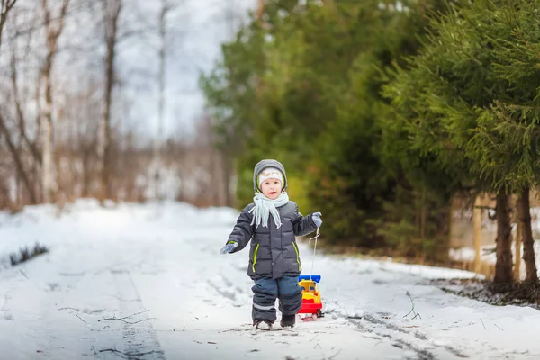 Piccolo ragazzo gioca con il suo giocattolo dump truck — Foto Stock