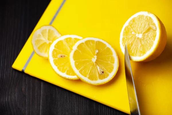 Нарезанный лимон на желтой доске — стоковое фото