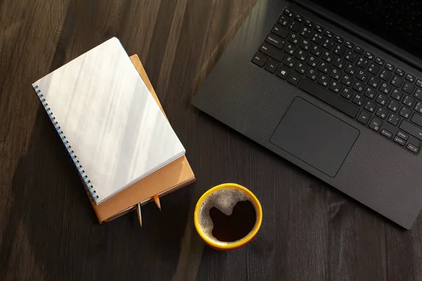 Mok van zwarte koffie en geopende laptop. Bovenaanzicht — Stockfoto