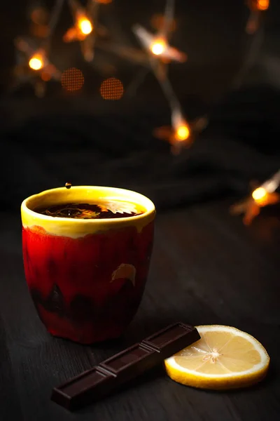 Una taza de té sobre fondo oscuro con luces navideñas —  Fotos de Stock