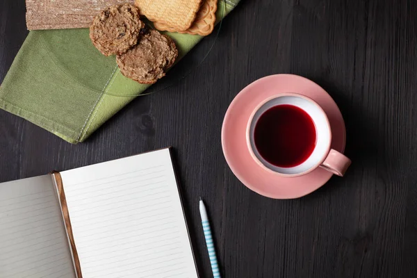 Ένα βιβλίο, ένα φλιτζάνι τσάι, ένα στυλό και ένα μπισκότο — Φωτογραφία Αρχείου