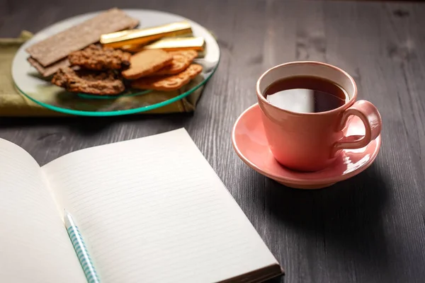 Leeres Notizbuch, Tasse Tee und Kekse — Stockfoto