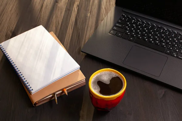 Close up of mug of coffee on desk with laptop — Stock Photo, Image