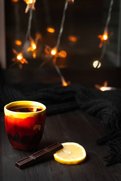 A ceramics mug of tea on dark background with Christmas lights — Stock Photo, Image