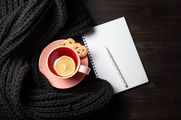 Copybook claro com xícara de chá em fundo de madeira preta — Fotografia de Stock
