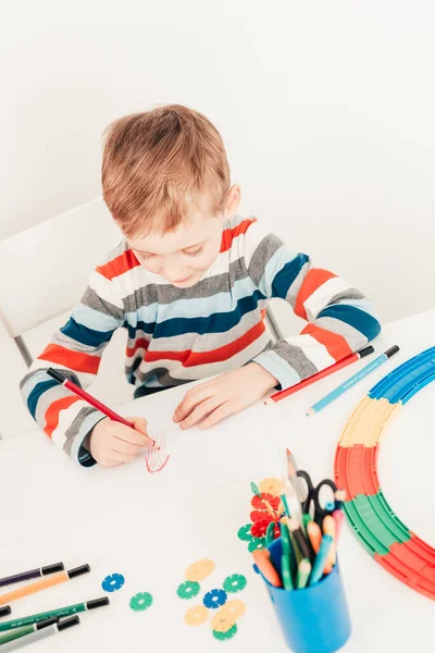 Çocuk beyaz masada resim çiziyor — Stok fotoğraf