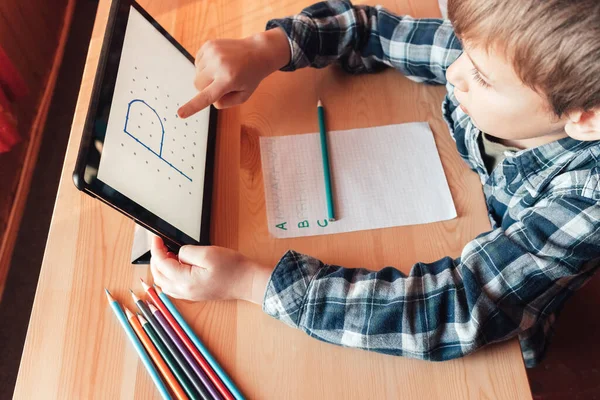 现代儿童在平板电脑上使用应用程序在家中学习和绘画 — 图库照片