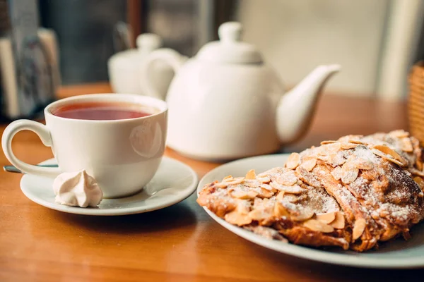 在咖啡店里 用热茶 茶壶和盘子里的新鲜羊角面包 把杯子关上 — 图库照片