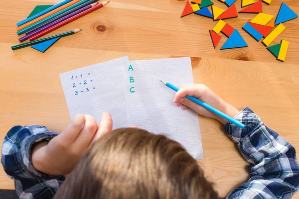 Bambino si siede a fare lezioni alla scrivania — Foto Stock