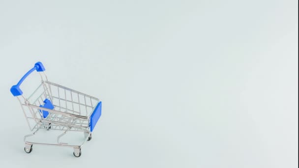 空のショッピングカートが表示され、それに落ちるギフトボックス — ストック動画