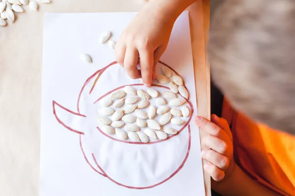 Little child making pumpkin from seeds , Halloween DIY concept — Stock Photo, Image