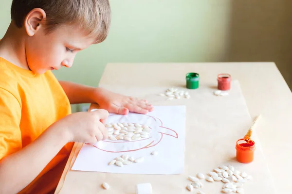 ホワイトペーパーの種からカボチャを作る幸せな男の子、ハロウィンDIYコンセプト — ストック写真