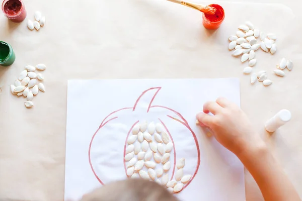 Happy child making labu from seeds, Halloween DIY concept — Stok Foto