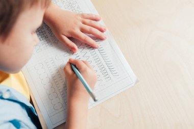 Kalemle iz süren sevimli çocuğa yaklaş.