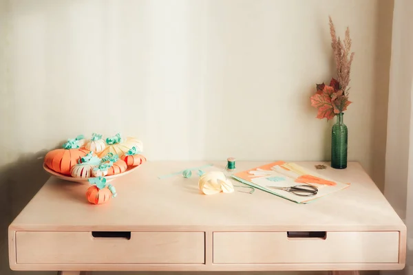 Asztal a fal közelében, papírból készült kézműves anyagokkal — Stock Fotó