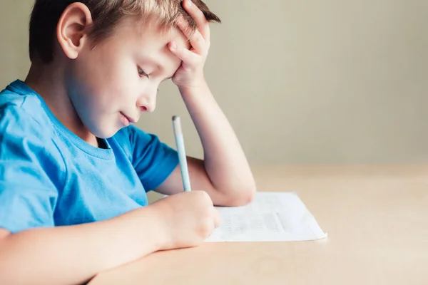 Seitenblick auf niedlichen Jungen, der seine Hausaufgaben macht. — Stockfoto