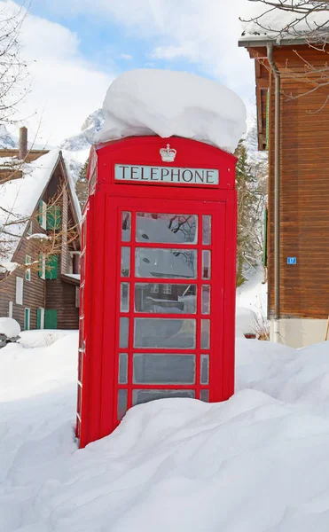雪のアルプスの有名な赤い電話ブース — ストック写真