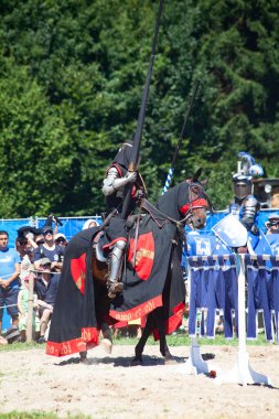 AGASUL, SWitzERLAND - 18 Ağustos 2012 'de Agasul, Canton Zürih, İsviçre' deki Kyburg şatosunun yeniden inşası sırasında attaki şövalye zırhı giymiş kimliği belirsiz adamlar harekete geçmeye hazırlar..
