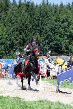 AGASUL, SWitzERLAND - 18 Ağustos 2012 'de Agasul, Canton Zürih, İsviçre' deki Kyburg şatosunun yeniden inşası sırasında attaki şövalye zırhı giymiş kimliği belirsiz adamlar harekete geçmeye hazırlar..
