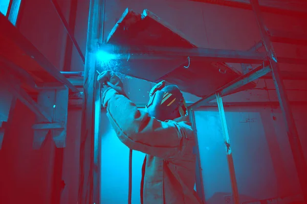 Welder in mask welding metal construction on open air. — Stock Photo, Image