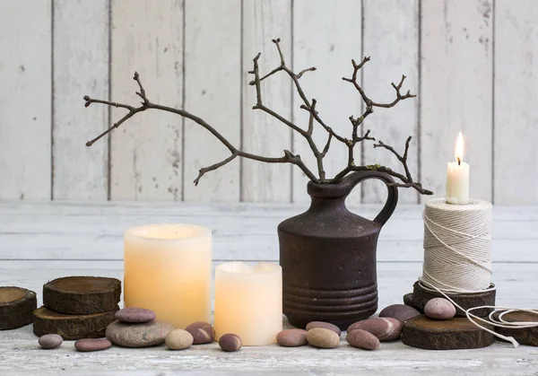 Décoration rustique avec bougies, vieux moulinet et brindilles dans un vase sur fond de bois blanc — Photo