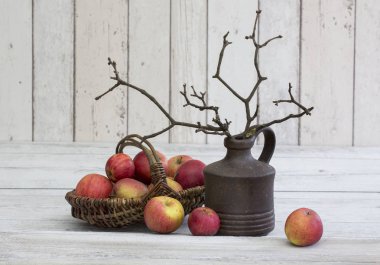 Elma ve twigs Beyaz ahşap zemin üzerinde bir vazoda ile rustik decoraton