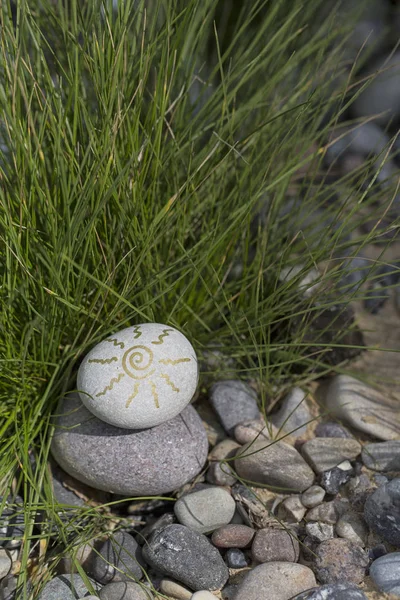 Pebble with sun symbol — Stock Photo, Image