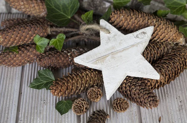 Cones de pinheiro e estrela de madeira — Fotografia de Stock