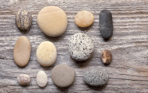 Smooth grey pebble on wood — Stock Photo, Image