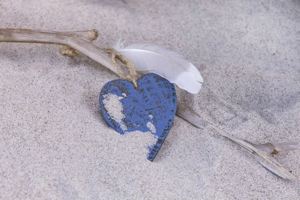 Spiaggia natura morta con blu cuore e piuma — Foto Stock