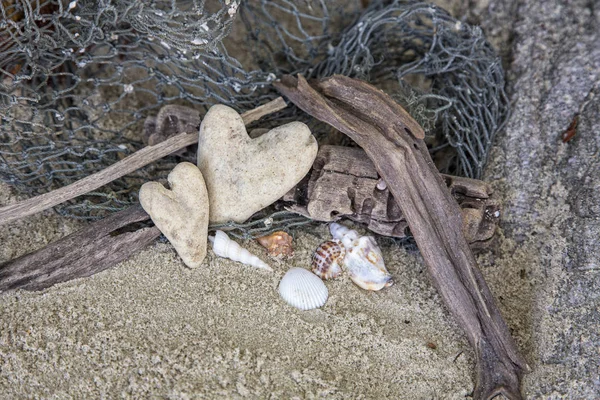 Пляжный натюрморт с каменными сердечками — стоковое фото